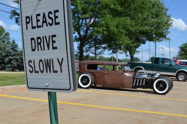 1928 ford rat rod near a drive slowly sign