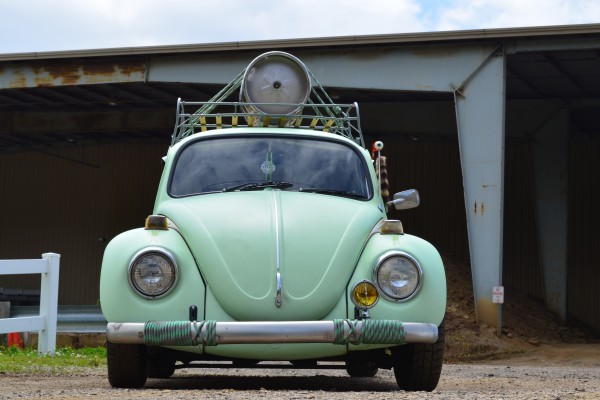front view of a VW Beetle with a beer keg on its rooftop luggage rack