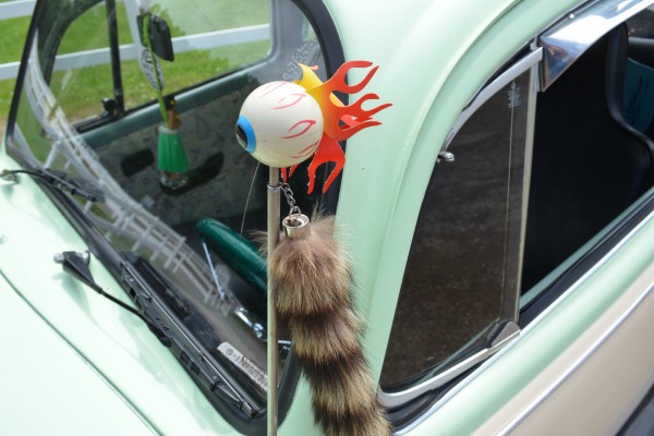 flamed eyeball and racoon tail antenna topper on an old VW beetle