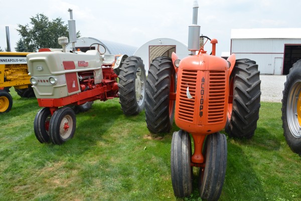 vintage ford and co-op tractors at an antique farm equipment show