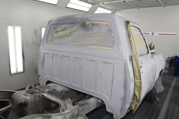 truck cab in primer waiting for paint in a spray booth