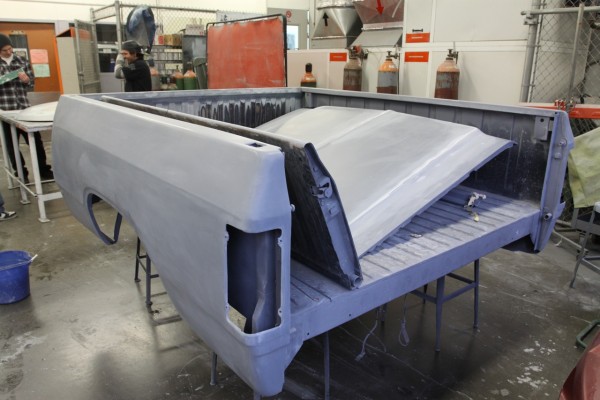 truck bed, hood, and tailgate being prepped for paint in a spray booth