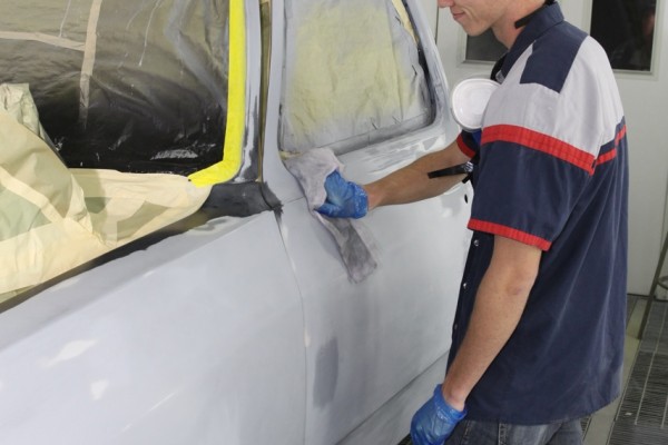 man washing a truck cab clean prior to painting in a spray booth