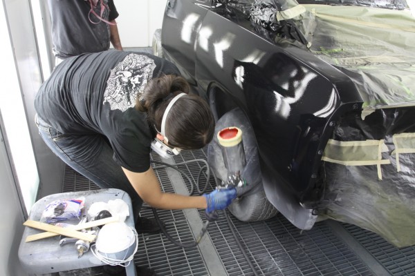 spraying inside fenders of a truck in a spray booth