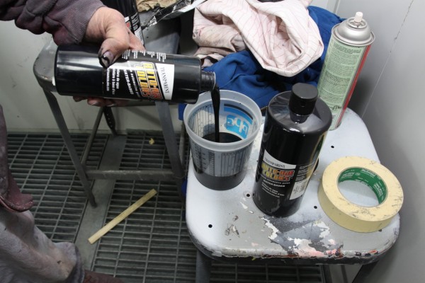 mixing black automotive paint into a spray gun cup