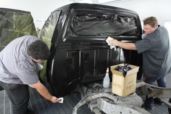 men sanding and scuffing paint on a truck cab prior to clearcoat