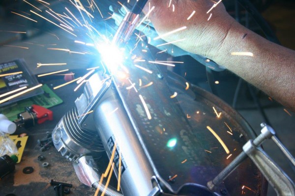 welding mounting fasteners onto an air compressor
