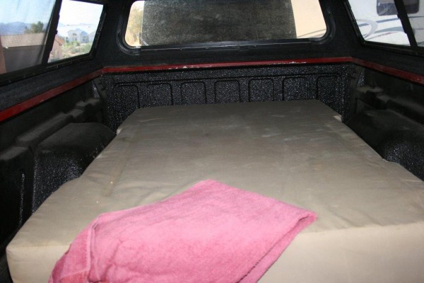 seeping mattress in the bed of a custom made camping trailer