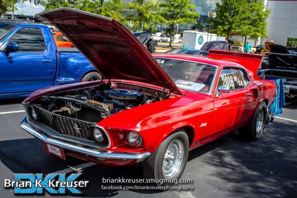 red 1969 ford mustang drag car at a neighborhood cruise in