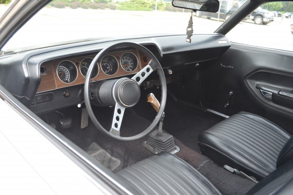 interior of a white 1973 plymouth cuda with a pistol grip 4 speed