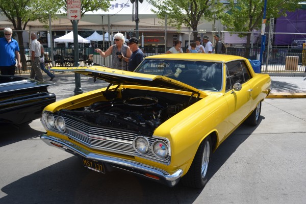 yellow first gen Chevy Chevelle parked on street during hot august nights