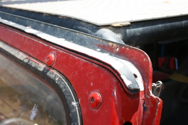close up of an old windshield soft top rail on a jeep cj