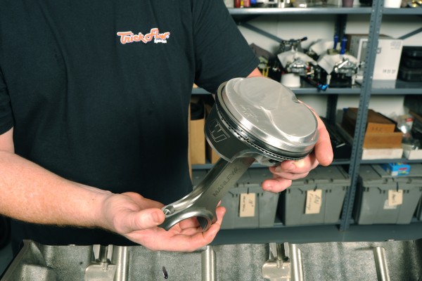 man holding a piston and connecting rod assembly