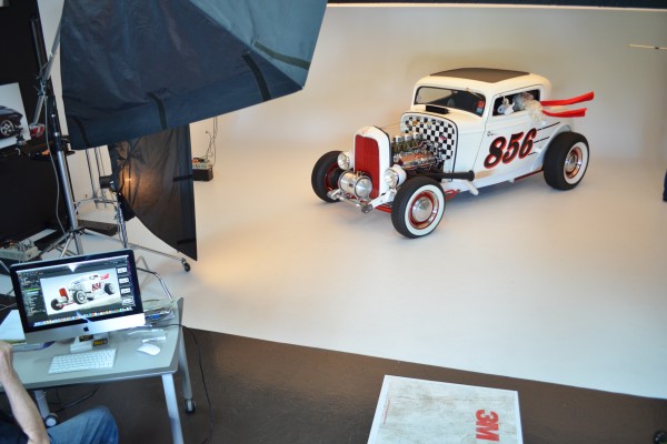 Santa claus driving a ford hot rod in a photo studio