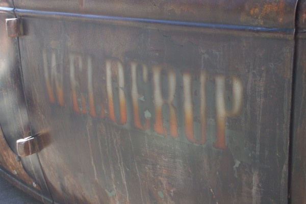 welderup patina graphic on the door of an old hot rod