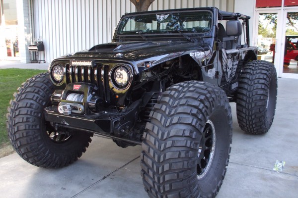 jeep wrangler with monster truck wheels on display at 2014 SEMA Trade Show