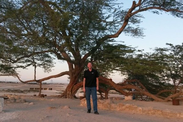 man standing in front of African tree