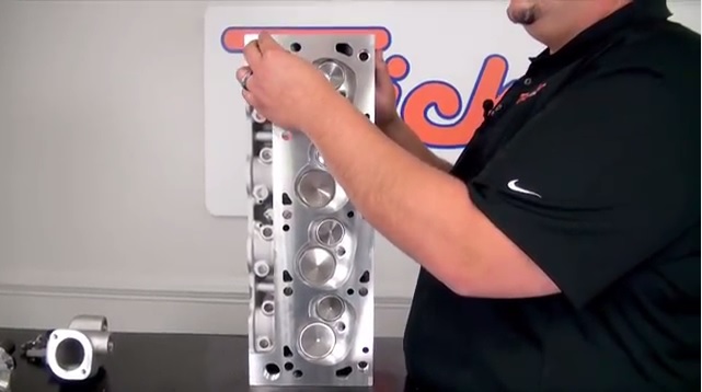 man showing where water crossover passage is on a cylinder head