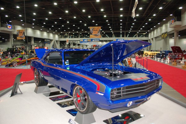 blue custom chevy camaro on display in indoor car show