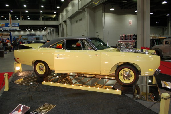 yellow plymouth road runner on display in indoor car show