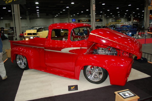 red vintage hot rod pickup truck on display in indoor car show