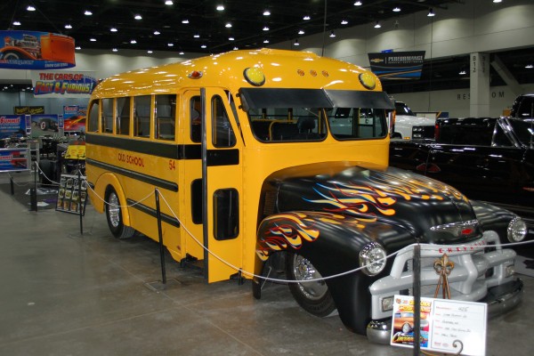 hot rod Chevy school bus on display in indoor car show