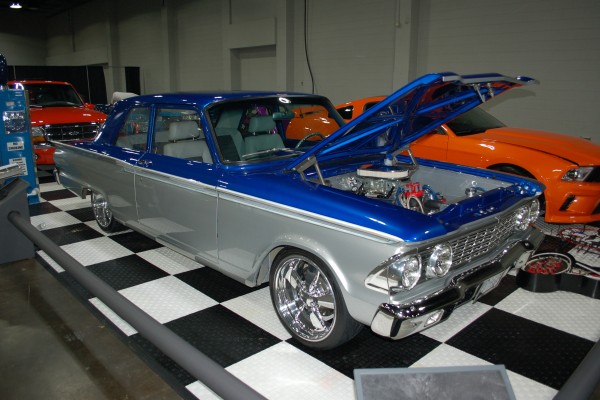 1960s era customized hot rod coupe on display in indoor car show