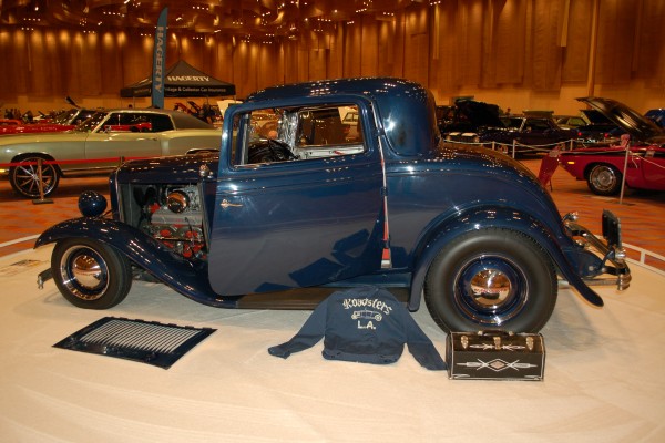 blue ford 3 window hot rod coupe on display in indoor car show