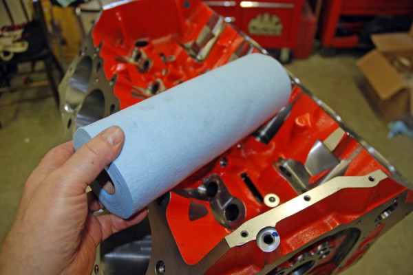 man holding paper towels near an engine