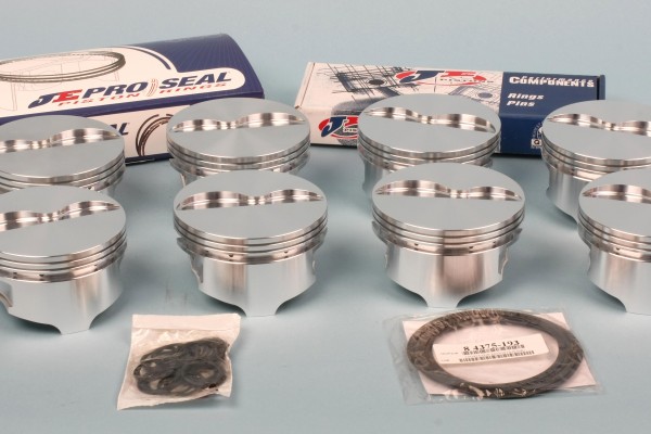 collection of engine bearings and pistons on a table