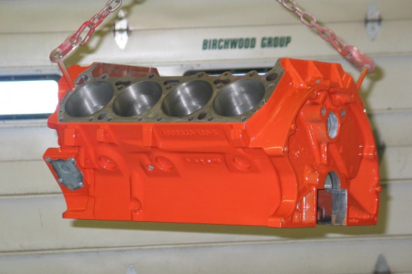 a big block engine being suspended on a chain hoist