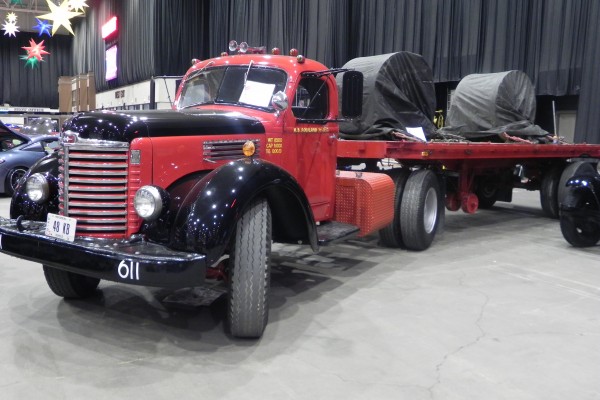 vintage semi truck with flatbed trailer at indoor car show