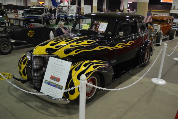 flamed hotrod coupe on display at indoor car show