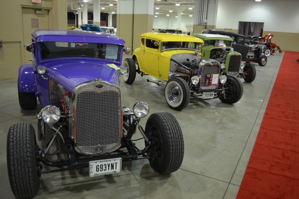 row of classic hotrods at indoor car show