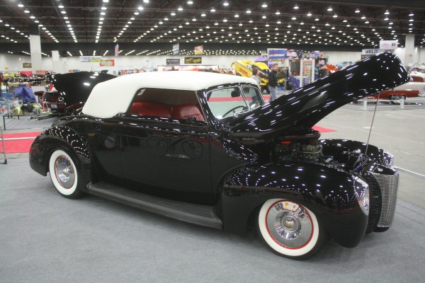 custom black hotrod ragtop on display at indoor car show