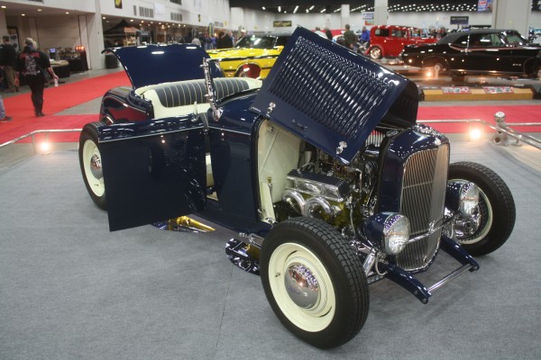 blue vintage ford hotrod convertible roadster on display at indoor car show