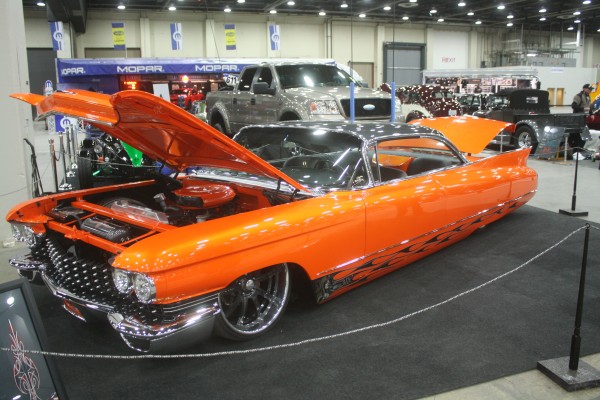 lowered 1960s cadillac hot rod coupe on display at indoor car show
