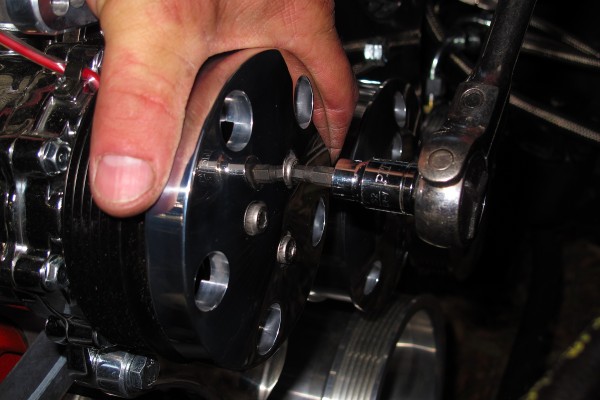 man installing an engine pulley cover