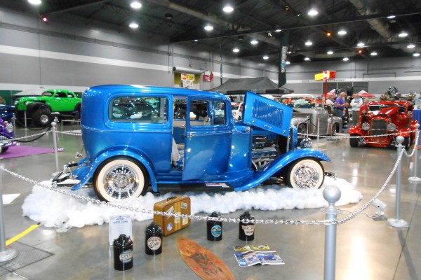 vintage blue hotrod coupe displayed at indoor car show