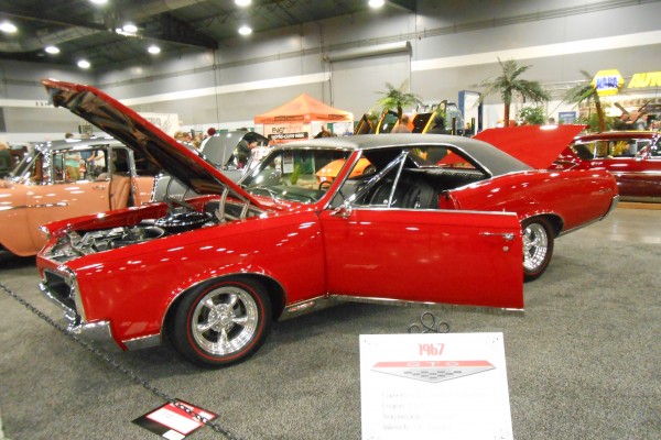 red 1967 pontiac gto hardtop displayed at indoor car show