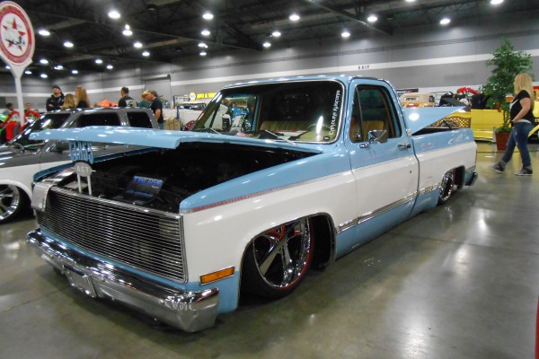 customized squarebody chevy truck displayed at indoor car show