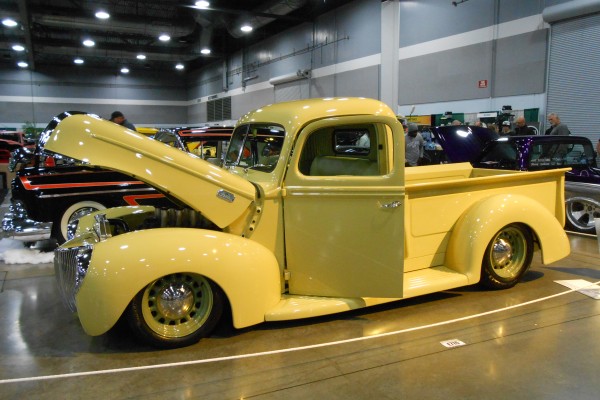 vintage yellow pickup truck displayed at indoor car show
