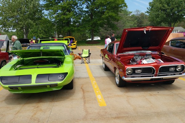 a plymouth superbird and second gen plymouth barracuda at car show