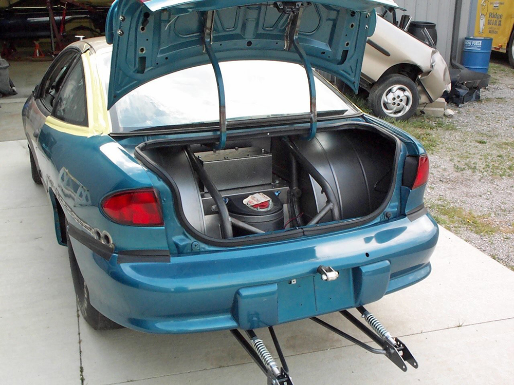 rear trunk of a super stock chevy cavalier with a ballast box