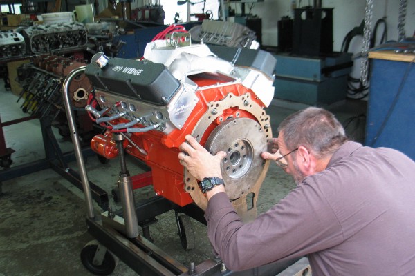 man installing dyno drive plate onto a mopar 499 engine prior to test