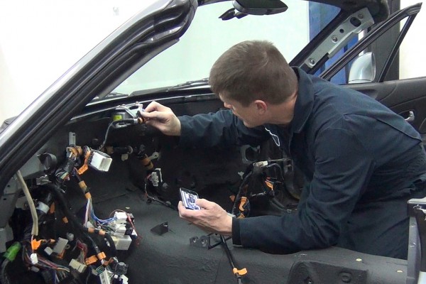 man installing connectors and wire harness into a mazda miata with an ls swap