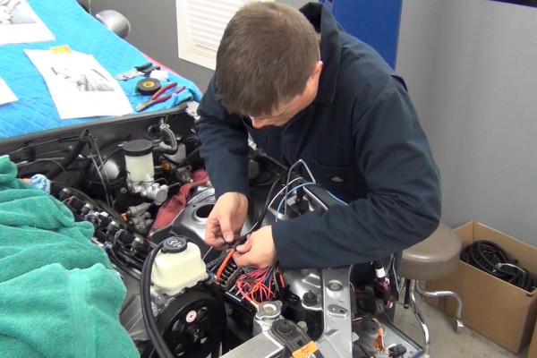 man wiring up an engine wiring harness