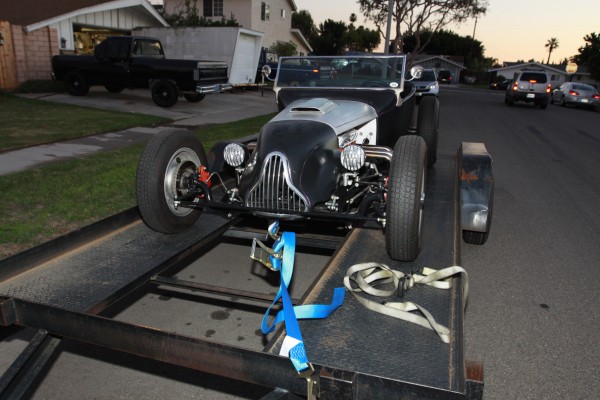 an ld hot rod tied down to a car trailer