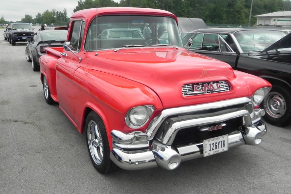 antique red gmc pickup truck at car show