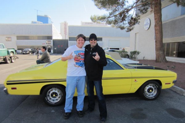 two men pose with a vintage dodge demon